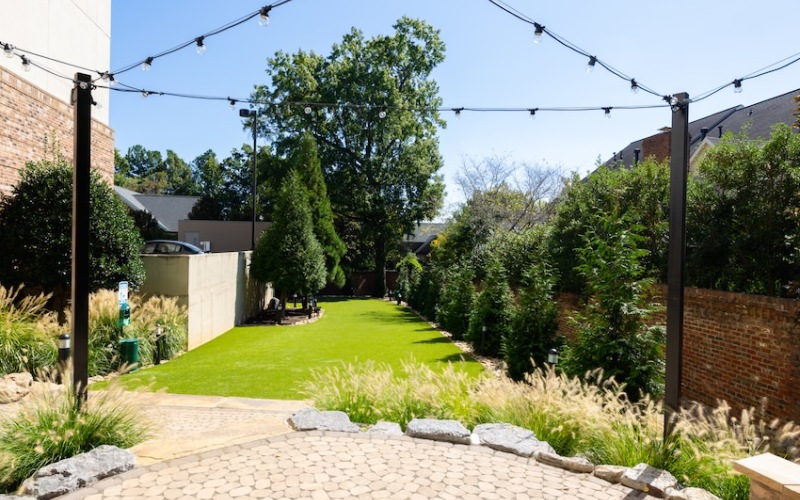 Stone Patio with String Lights and Open Air Dog Park